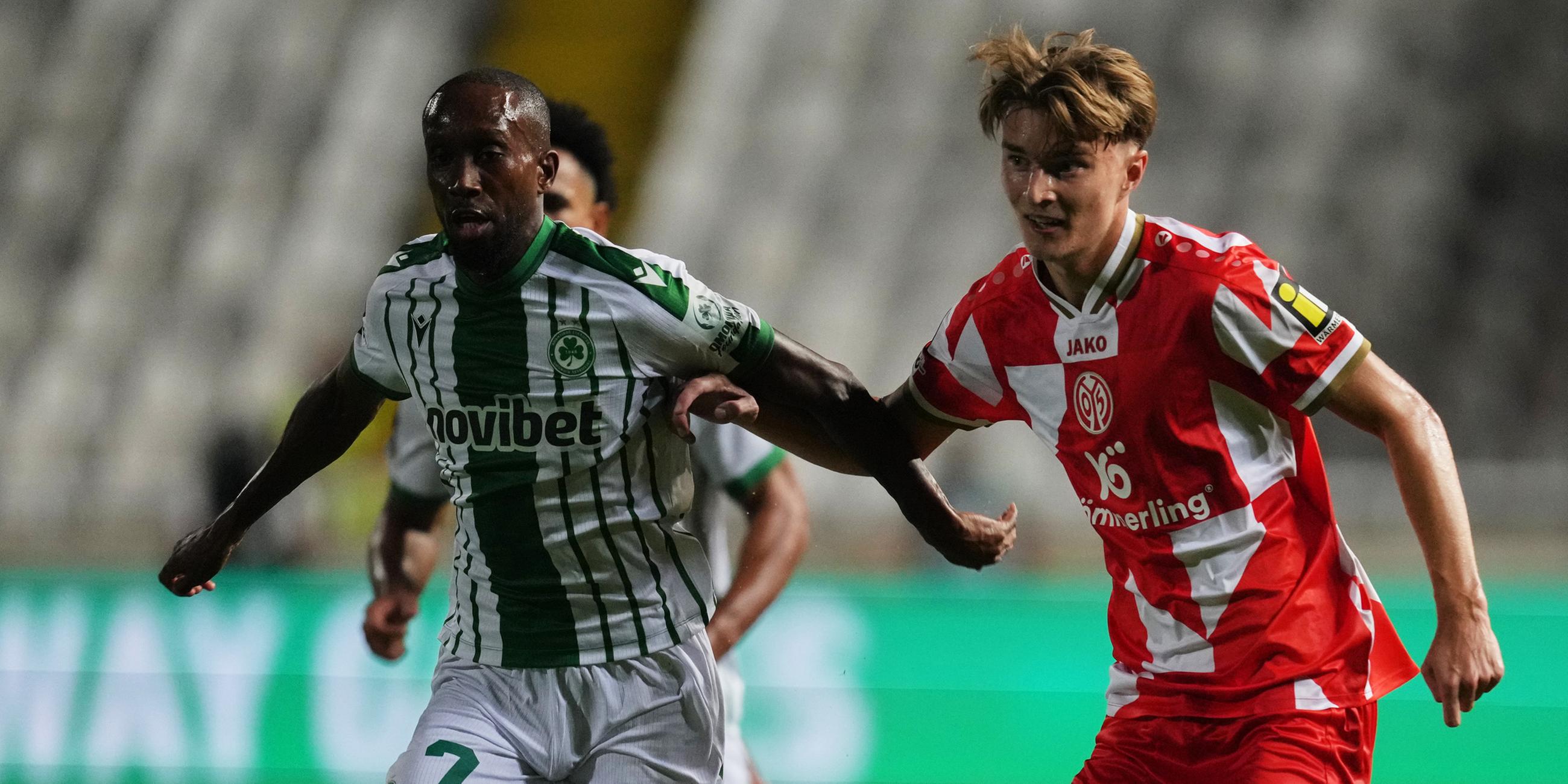 02.10.2025, Nikosia: Willy Semedo (l.) von Omonia wird im Conference-League-Spiel gegen Mainz 05 von Kacper Potulski unter Druck gesetzt.