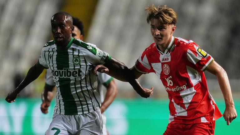 02.10.2025, Nikosia: Willy Semedo (l.) von Omonia wird im Conference-League-Spiel gegen Mainz 05 von Kacper Potulski unter Druck gesetzt.