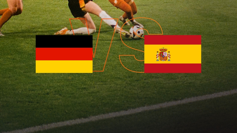 Deutsche und spanische Flagge vor grünem Rasen.