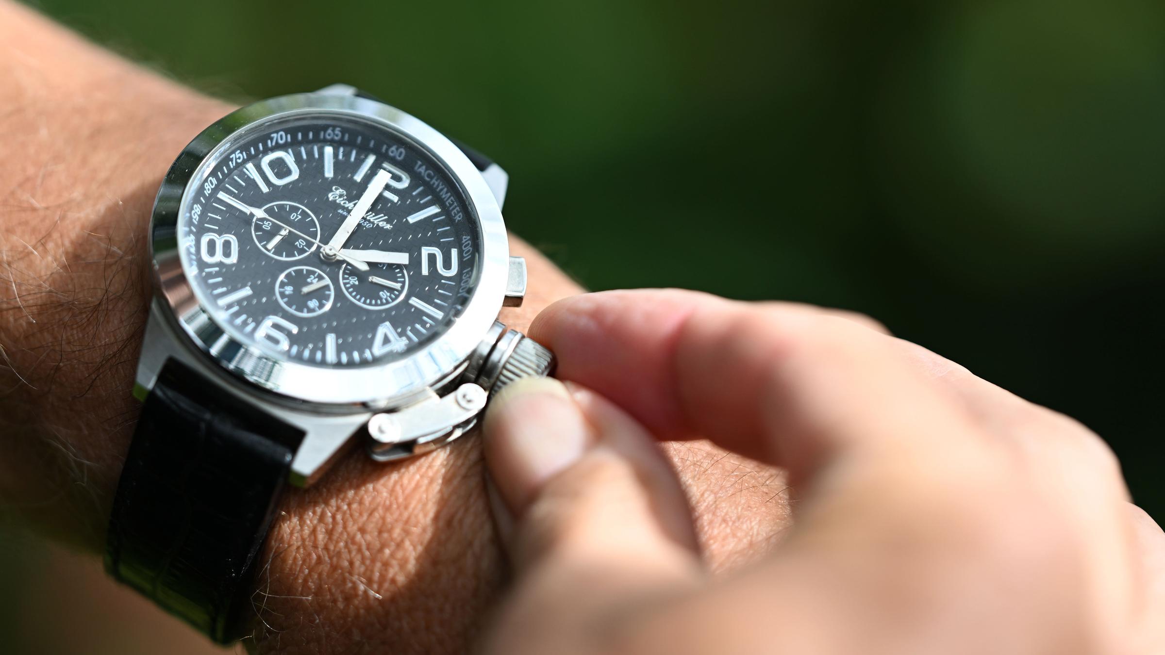 Eine Armbanduhr wird bei Sonnenstrahlen nach vorne gestellt.