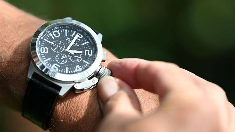 Eine Armbanduhr wird bei Sonnenstrahlen nach vorne gestellt.