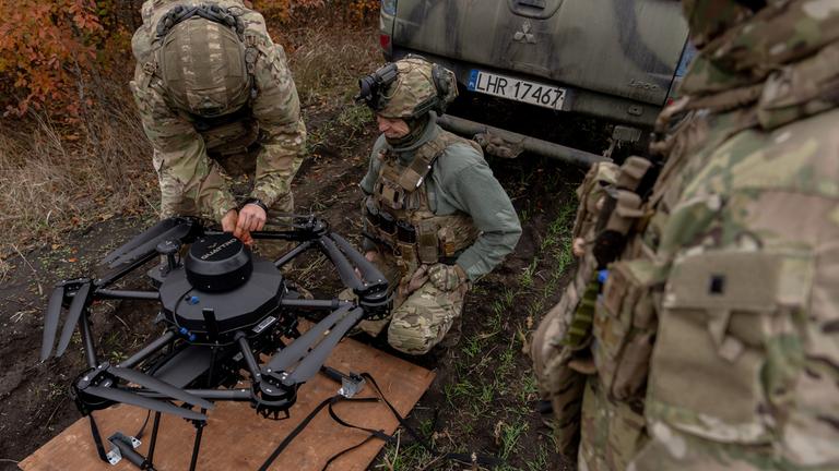 Drei Ukrainische Soldaten auf einem Panzer  bereiten eine Vampir-Drohne vor