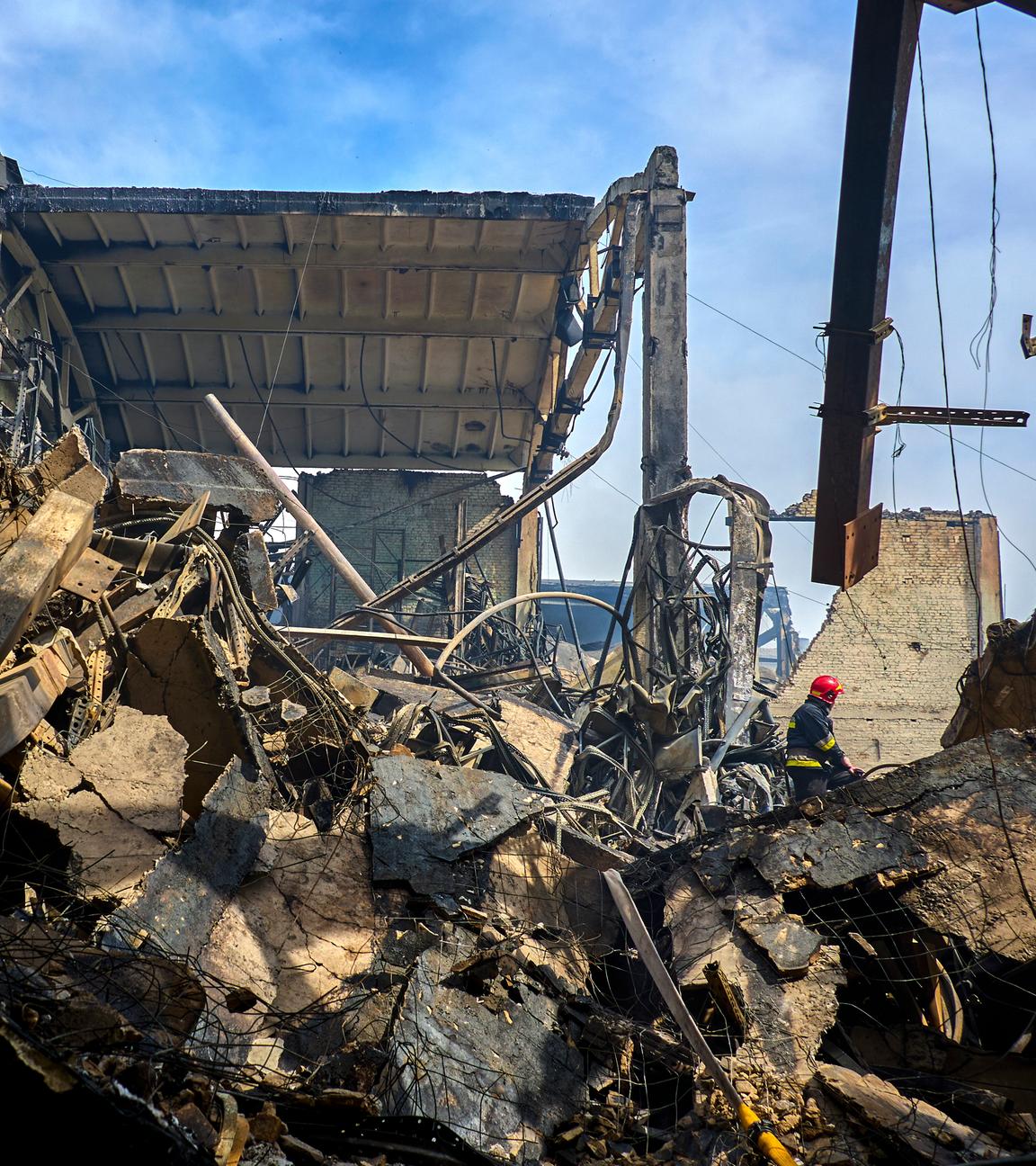 Ukrainische Feuerwehrleute und Rettungskräfte arbeiten an der Stelle eines beschädigten Lagers einer privaten Fabrik nach einem nächtlichen Angriff in Wasyschtschewe, Ukraine.