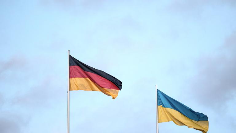 21.05.2022, Rheinland-Pfalz, Mainz: Eine deutsche (l) und eine ukrainische Flagge wehen im Wind. 