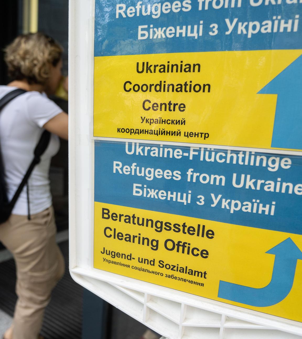 Besucher gehen an einem Hinweisschild der Initiative Ukrainian Coordination Center (UCC) am Eingang zum Amt für multikulturelle Angelegenheiten der Stadt Frankfurt am Main vorbei.