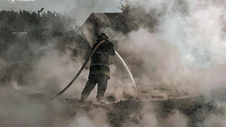 It shows a firefighter extinguishing a fire after a Russian attack in Kyiv region.