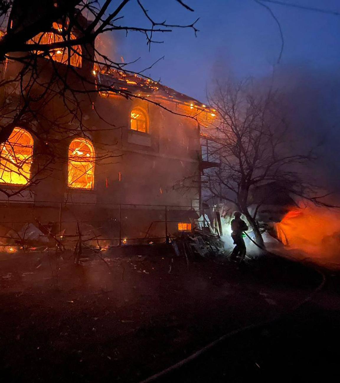 Feuerwehrleute löschen ein brennedes Gebäude in Kiew nach einem russischen Raketenangriff.