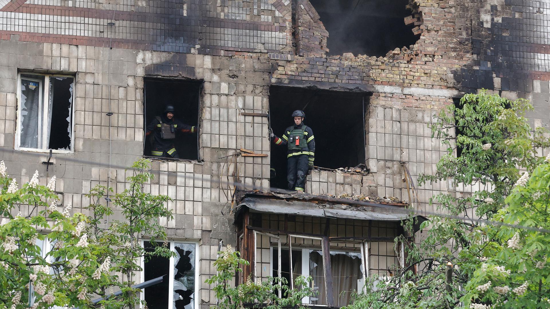 Ukrainische Einsatzkräfte stehen in einem beschädigten Gebäude in Kiew nach einem russischen Angriff.