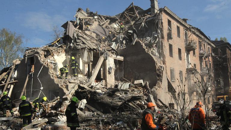 Rettungskräfte suchen unter den Trümmern eines vierstöckigen Wohnhauses nach Überlebenden.