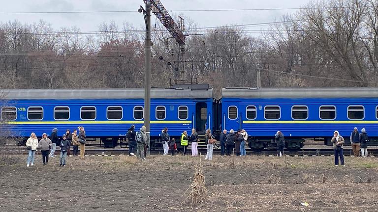 Passagiere warten außerhalb eines ukrainischen Zuges.