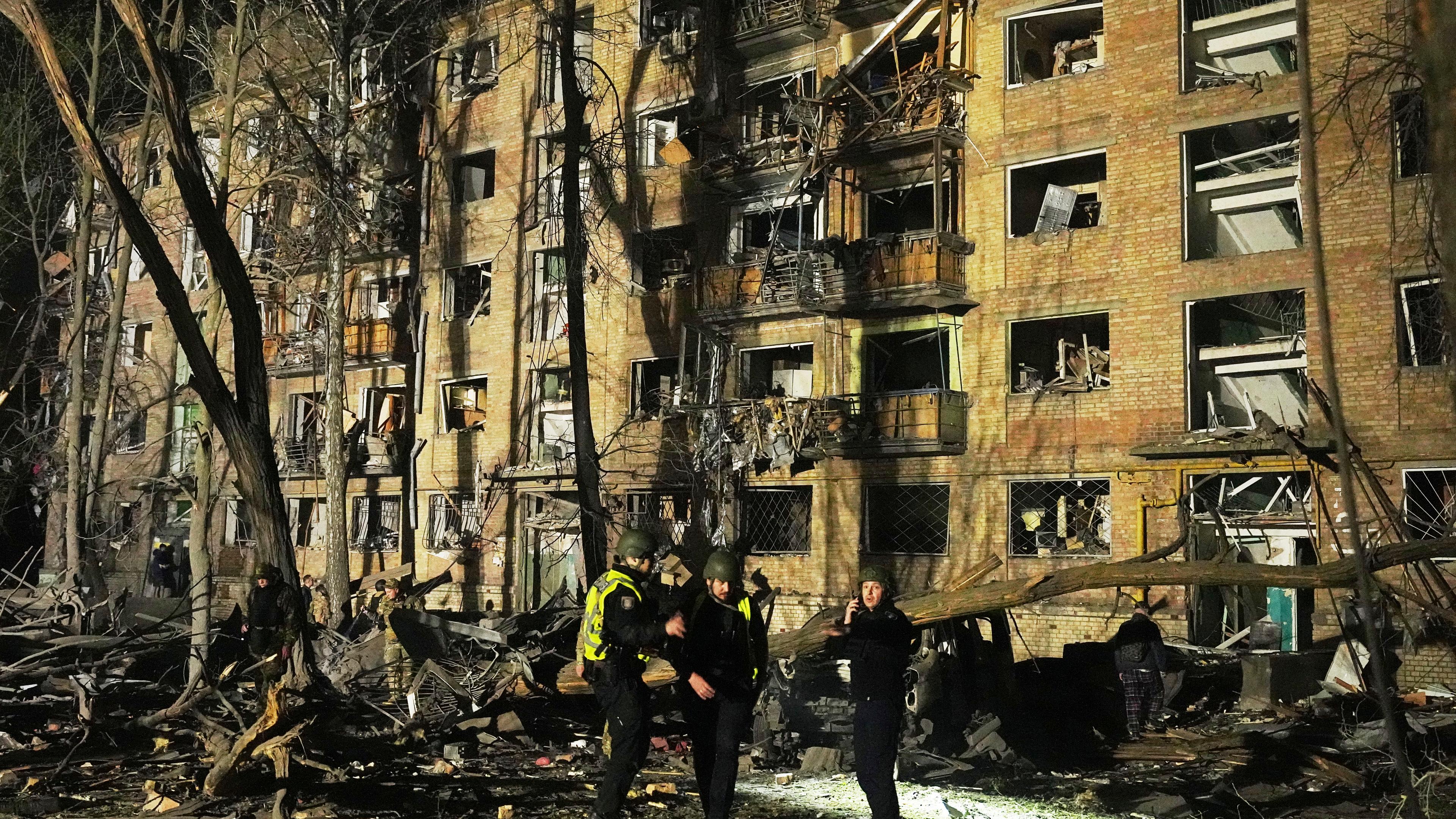 Ukrainische Polizisten stehen am frühen Donnerstag, dem 24. April 2025, in der Nähe eines beschädigten Gebäudes nach einem russischen Angriff mit ballistischen Raketen in Kiew, Ukraine.