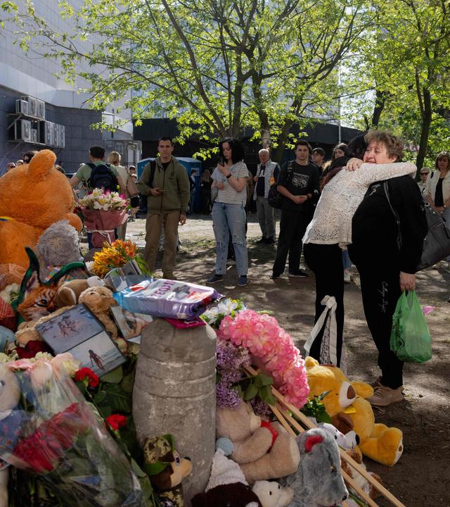 Kiew: Menschen trauern vor einem zerstörten Gebäude.