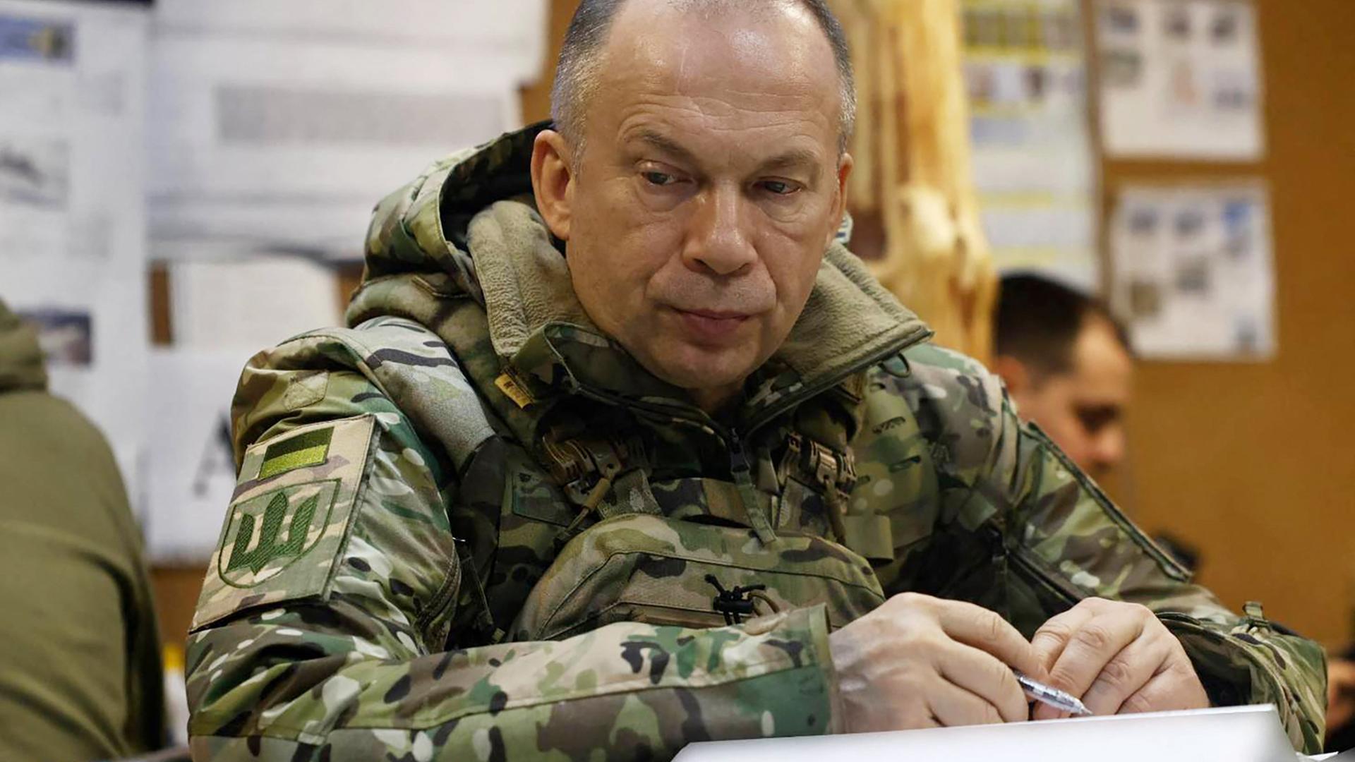 This handout photograph released on February 25, 2024, by the press service of the Ukrainian Armed Forces, shows Commander-in-Chief of the Armed Forces of Ukraine Oleksandr Syrsky (L) visiting the frontline positions at an undisclosed location in eastern Ukraine. 
