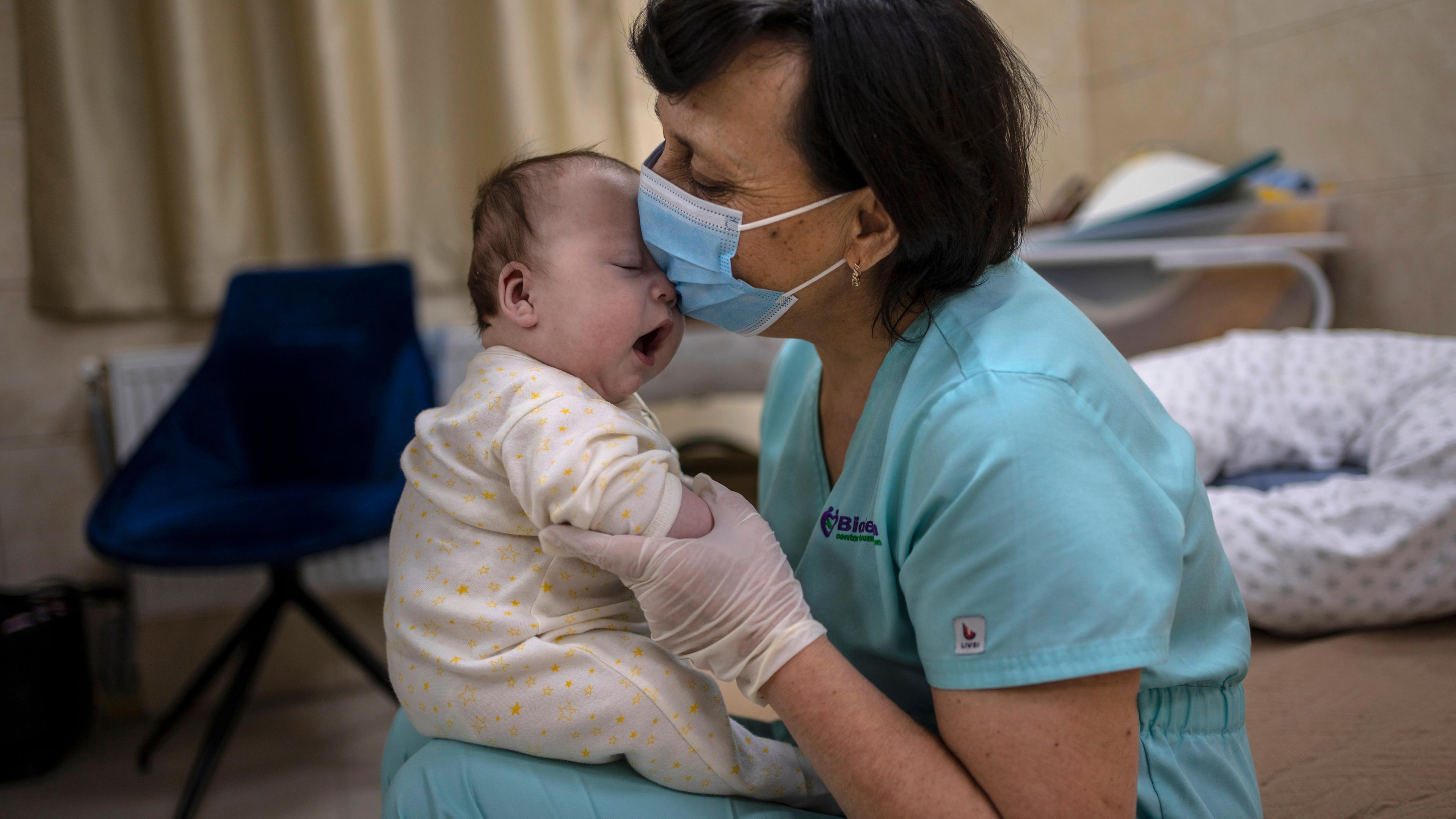 Ukraine, Kiew: Kindermädchen Svitlana Stetsiuk spielt mit einem Baby in einer Kinderkrippe. Archivbild