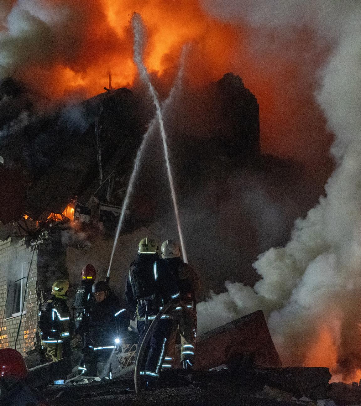  Feuerwehrleute bekämpfen einen Brand in einem Mehrfamilienhaus nach einem russischen Raketenangriff in Charkiw, Ukraine.