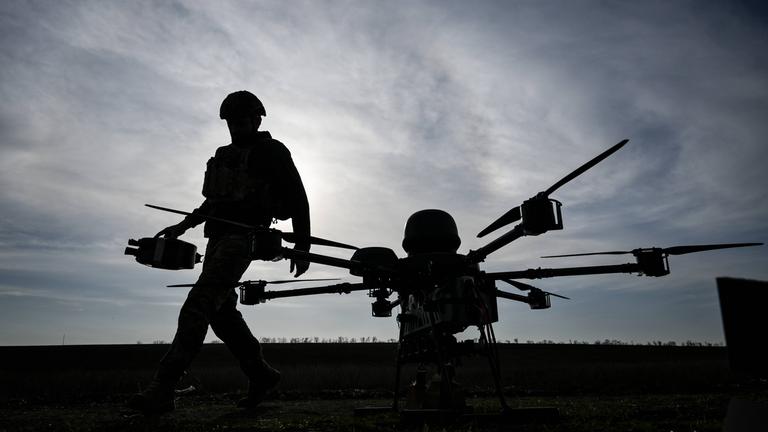 Ein Ukrainischer Soldat steht neben einer Drohne.
