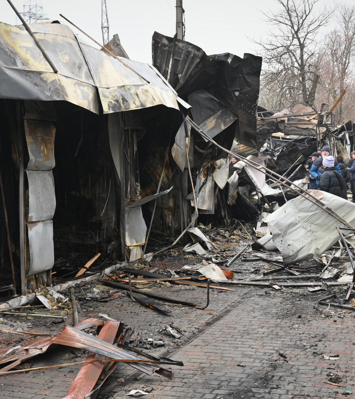 12.02.2026, Ukraine, Odesa: Menschen gehen über einen zerstörten Stadtmarkt nach einem russischen Angriff.