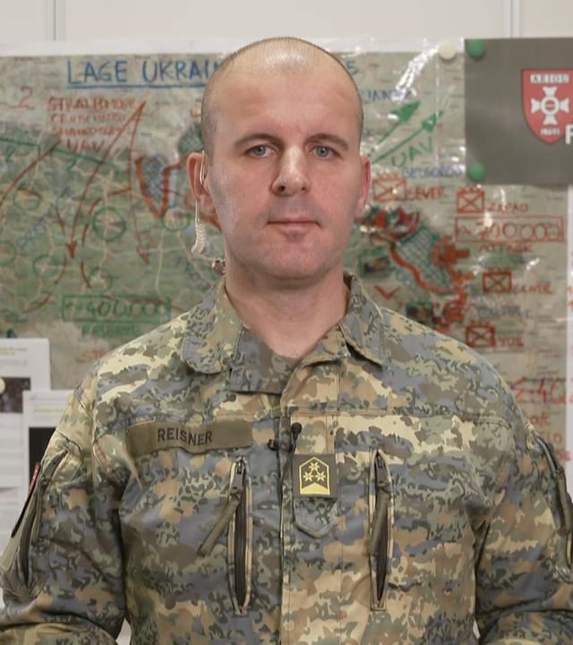 Oberst Markus Reisner in seinem Büro vor einer Ukraine Karte.