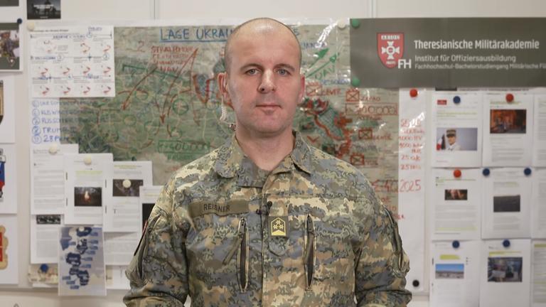 Oberst Markus Reisner in seinem Büro vor einer Ukraine Karte.