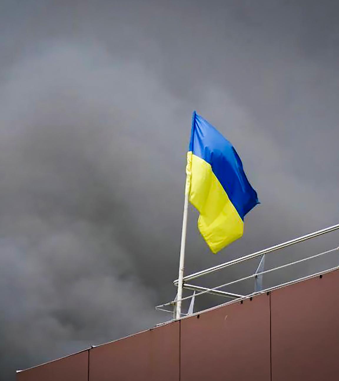 Auf diesem von der Regionalverwaltung Dnipropetrowsk veröffentlichten Foto weht die ukrainische Flagge, während nach einem russischen Raketenangriff Rauch aufsteigt. 