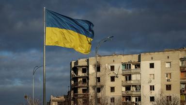 Die ukrainische Flagge weht vor einem zerstörten Haus in der Region Kiew