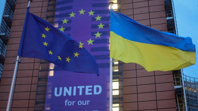 EU-Flagge und ukrainische Flagge vor EU-Kommission