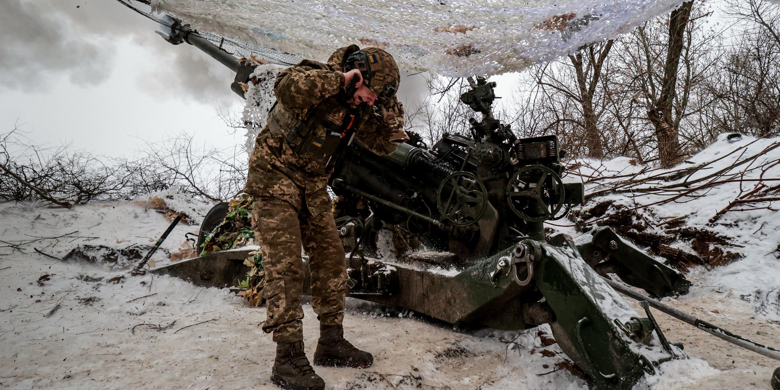 Ein Soldat hält sich vor Kriegsgerät die Ohren zu.
