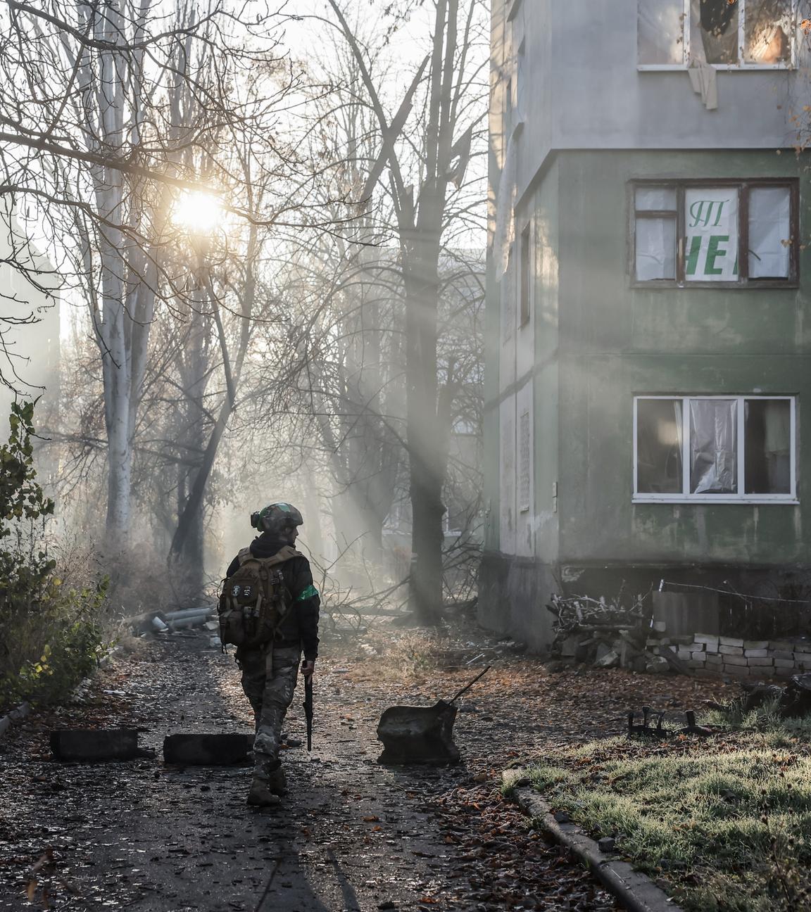 Ukrainischer Soldat läuft an Häuserfront vorbei