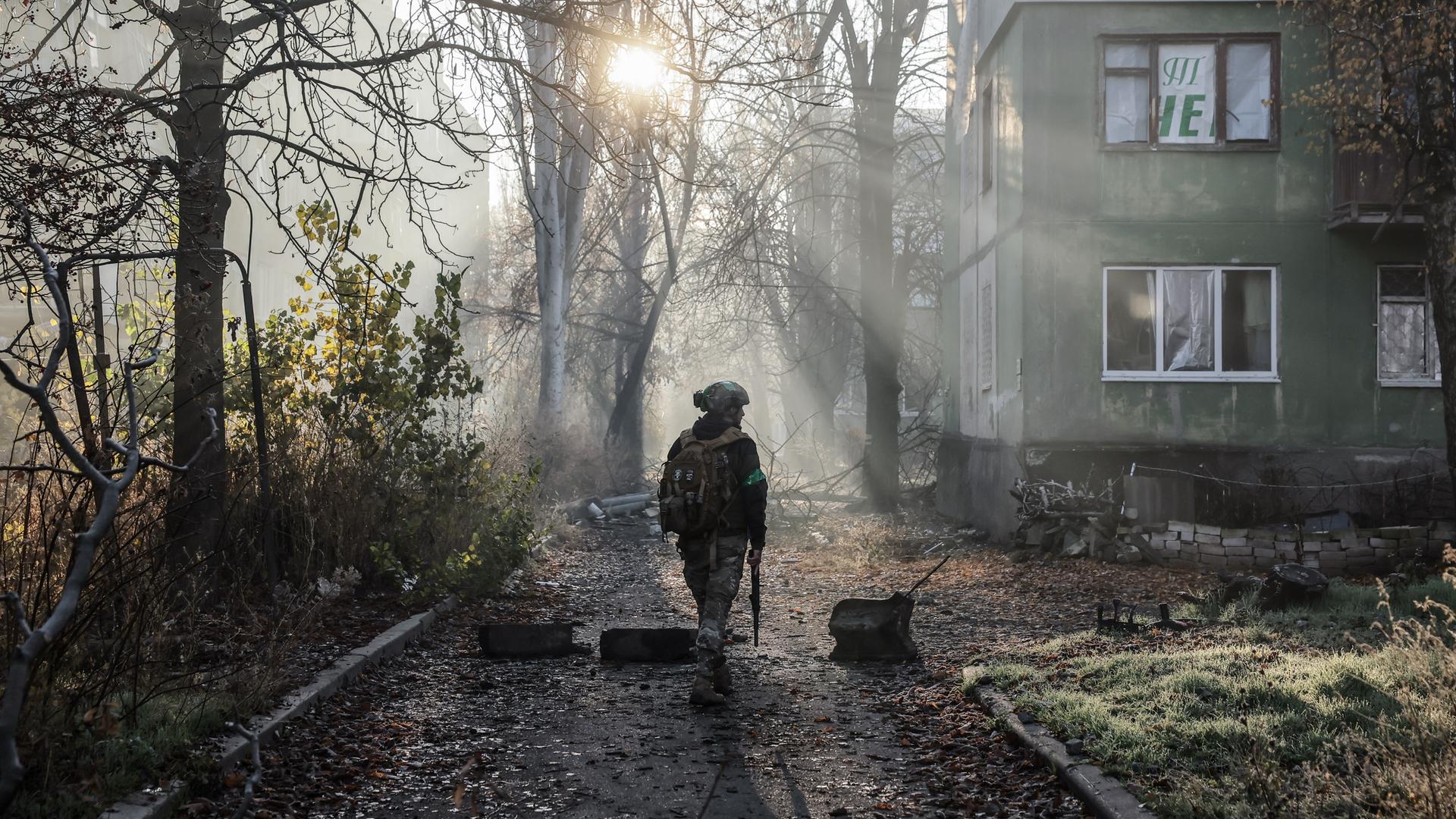 Ukrainischer Soldat läuft an Häuserfront vorbei