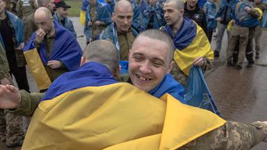 Freigelassene ukrainische Kriegsgefangene umarmen sich nach einem Gefangenenaustausch an einem nicht genannten Ort in der Region Tschernihiw am 15. Mai 2026.