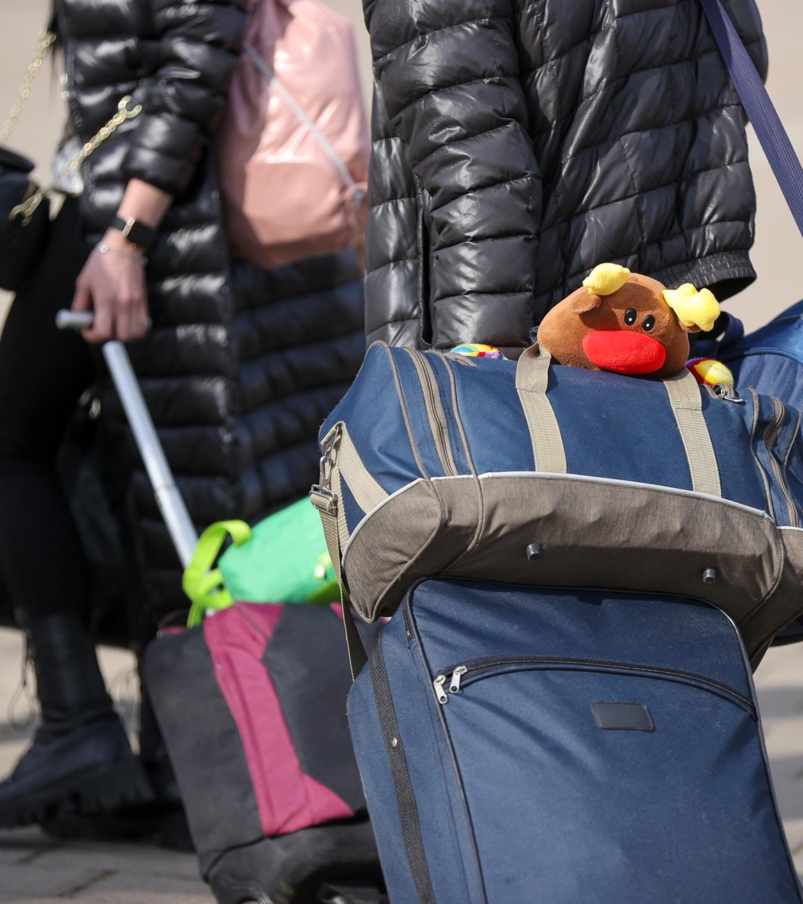 Ukrainische Flüchtlinge gehen mit ihrem Gepäck in eine Erstaufnahmeeinrichtung.