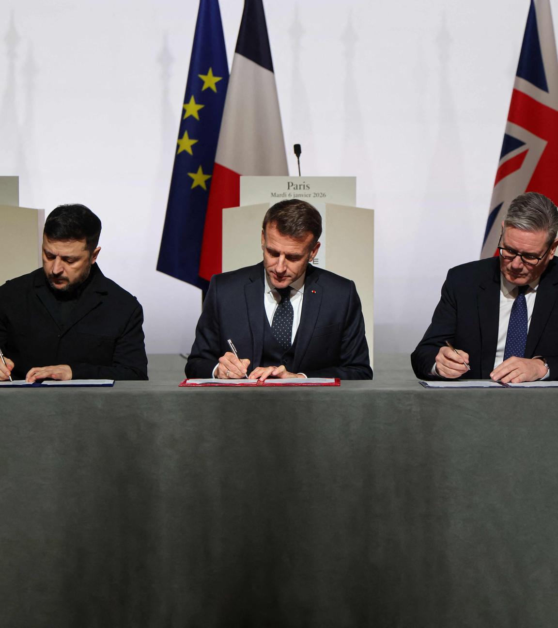 Der ukrainische Präsident Wolodymyr Selenskyj, der französische Präsident Emmanuel Macron und der britische Premierminister Keir Starmer unterzeichnen am 6. Januar 2026 im Élysée-Palast in Paris die Erklärung zum Einsatz von Streitkräften nach dem Waffenstillstand in der Ukraine. 
