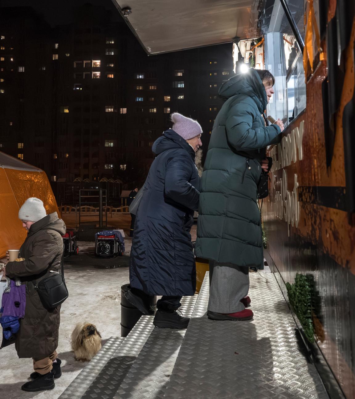 Die Bewohner erhalten am 28. Januar 2026 während der russischen Invasion warmes Essen und Getränke in einer mobilen Küche in Kiew,