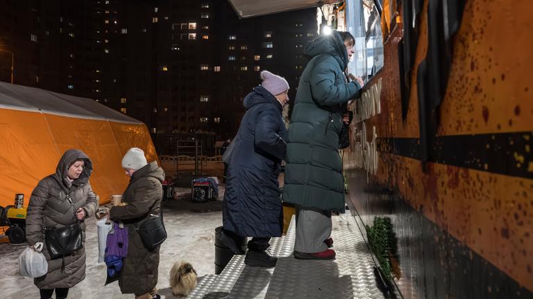 Die Bewohner erhalten am 28. Januar 2026 während der russischen Invasion warmes Essen und Getränke in einer mobilen Küche in Kiew,