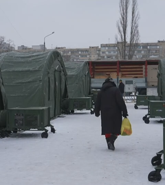 Eine Frau geht an den provisorischen Lagern vorbei im Winter.