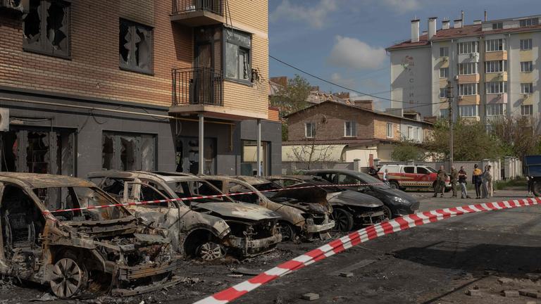 Ausgebrannte Autos vor einem beschädigten Wohngebäude nach russischen Drohnen- und Raketenangriffen in Kiew.