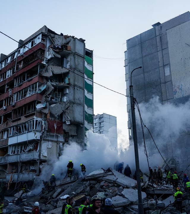 14.05.2026, Ukraine, Kiew: Rettungskräfte beseitigen die Trümmer eines Hauses, das nach einem russischen Angriff auf ein Wohnviertel schwer beschädigt wurde.