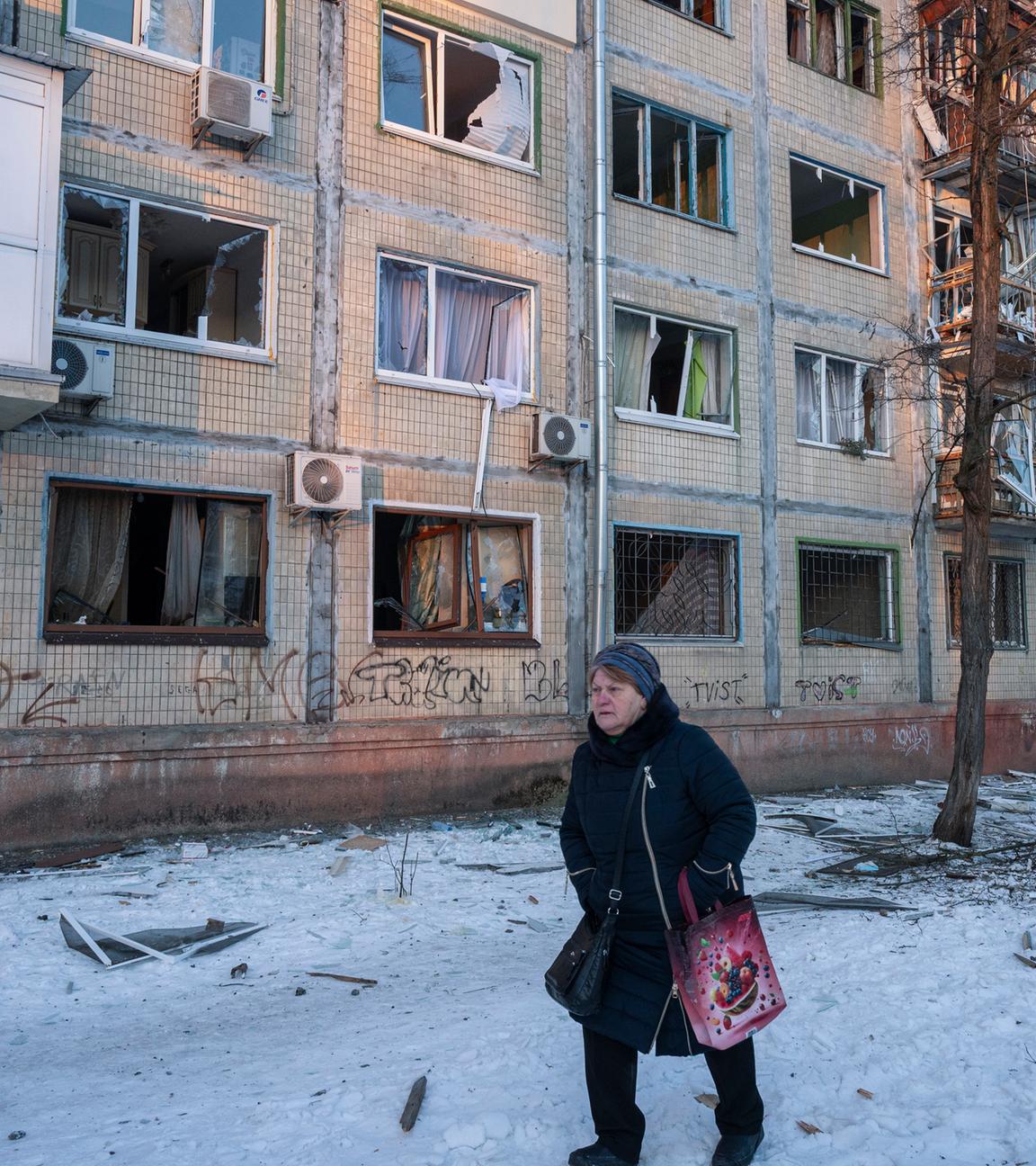 Eine Anwohnerin geht an der Stelle vorbei, wo ein russischer Drohnenangriff auf ein fünfstöckiges Wohngebäude in Kiew, Ukraine, stattgefunden hat.