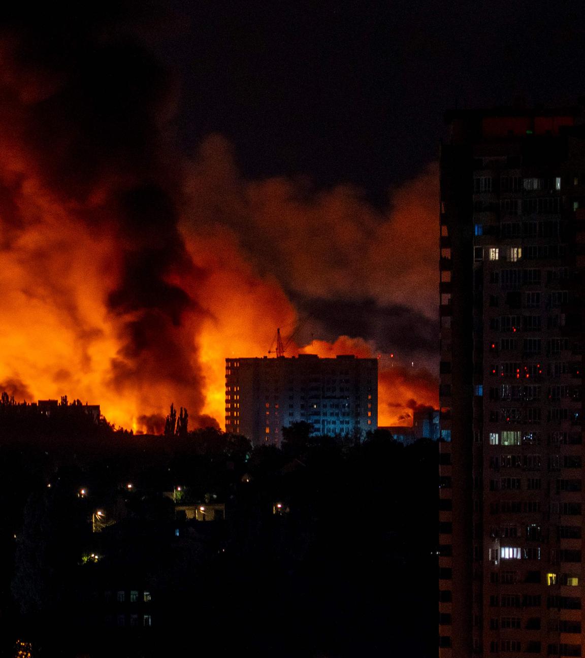 Während der russischen Invasion in der Ukraine am 4. Juli 2025 massenhaft russische Drohnen- und Raketenangriffe auf die ukrainische Hauptstadt schlagen Flammen und Rauch aus Gebäuden.