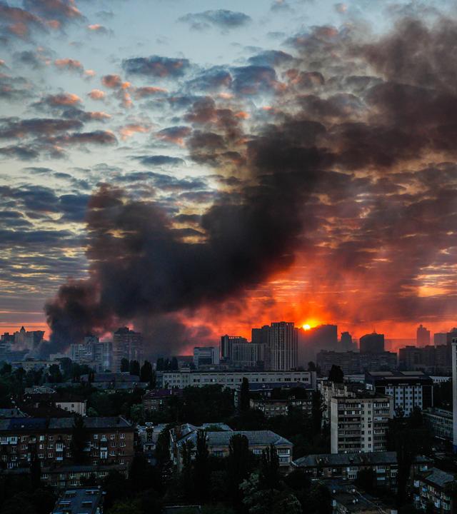 Nach einem heftigen russischen Luftangriff auf Kiew steigt bei Sonnenaufgang Rauch über der Stadt auf
