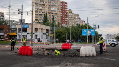 11.07.2026, Ukraine, Kiew: Mitarbeiter der Polizei untersuchen die Einschlagstelle einer russischen Rakete in einem Wohngebiet. 