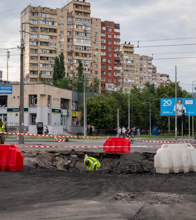 11.07.2026, Ukraine, Kiew: Mitarbeiter der Polizei untersuchen die Einschlagstelle einer russischen Rakete in einem Wohngebiet. 
