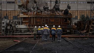 Kraftwerksarbeiter betrachten am 05.01.2023 einen Spannungswandler, der nach ukrainischen Angaben bei einem russischen Angriff zerstört wurde.