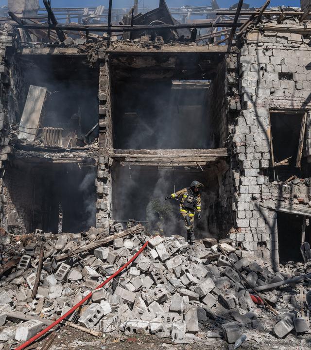 Ein Feuerwehrmann ist dabei zu sehen, wie er nach einem russischen Luftangriff einen Brand in einem Wohngebäude löscht.