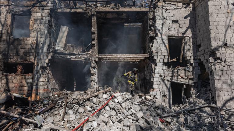 Ein Feuerwehrmann ist dabei zu sehen, wie er nach einem russischen Luftangriff einen Brand in einem Wohngebäude löscht.