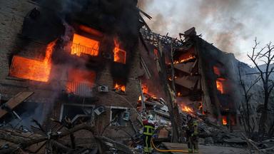 Ukraine, Kiew: Rettungskräfte löschen ein Feuer in einem Wohnhaus, das nach einem russischen Angriff in Kiew zerstört wurde.