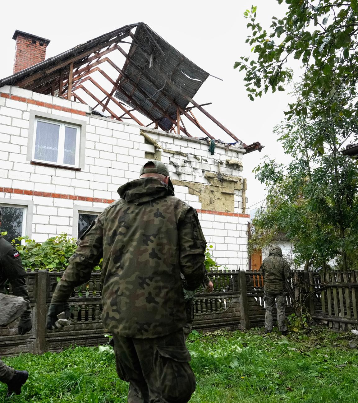 Archiv: Beamte der Territorialen Verteidigung räumen Trümmer vom zerstörten Dach eines Hauses auf, nachdem russische Drohnen den polnischen Luftraum verletzt haben. 