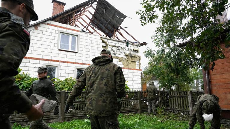 Archiv: Beamte der Territorialen Verteidigung räumen Trümmer vom zerstörten Dach eines Hauses auf, nachdem russische Drohnen den polnischen Luftraum verletzt haben. 