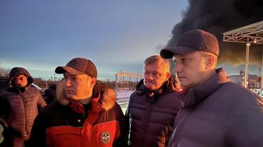 Auf diesem vom Telegram-Kanal des Gouverneurs der Region Saratow, Roman Busargin, am 8. Januar 2025 veröffentlichten undatierten Foto spricht der Gouverneur der Region Saratow, Roman Busargin (r) mit Feuerwehrleuten und Rettungskräften im nach dem Angriff ukrainischer Drohnen beschädigten Industriebereich.