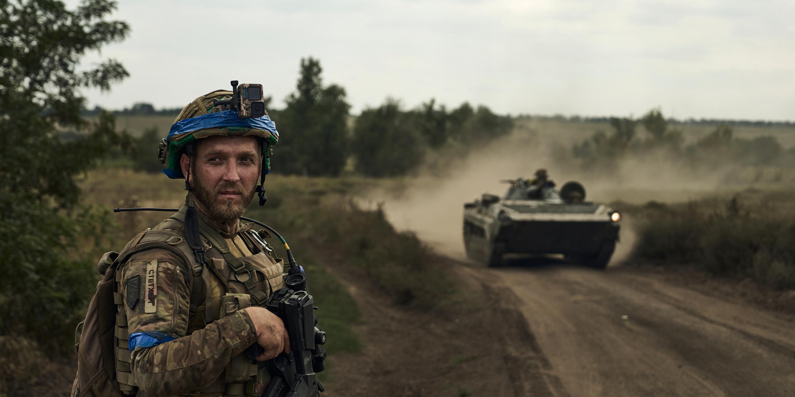 Ukraine-Krieg - Soldat in Bachmut steht vor Schützenpanzer, Archivbild